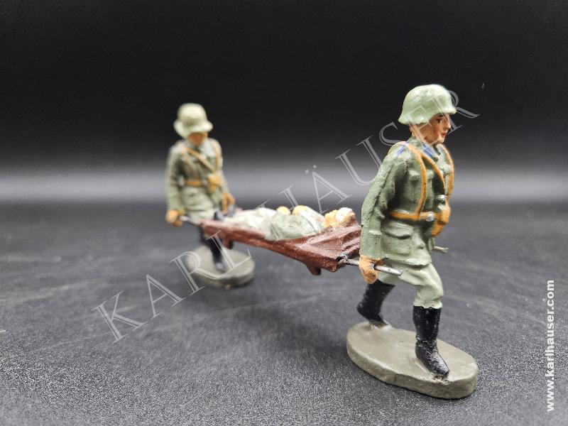 Art.  elastolin-heer-2-sanitatssoldaten-mit-verwundeten-auf-bahre-marschierend